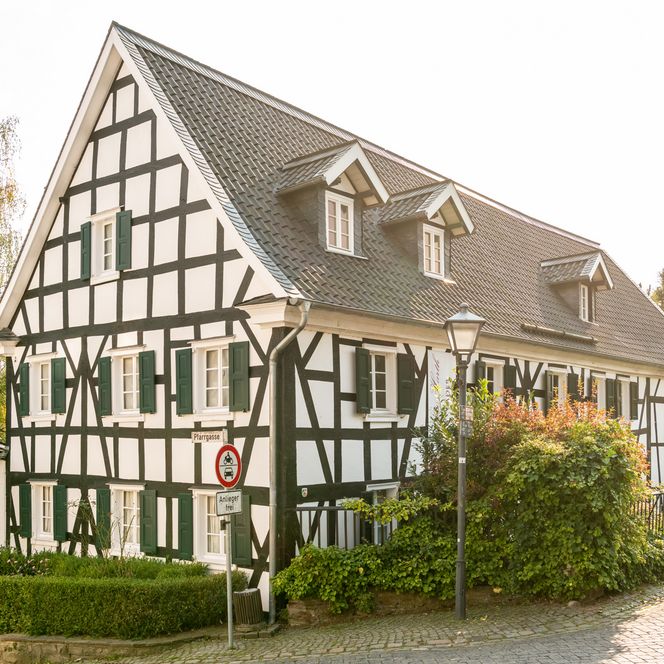 <p>Traditionelles Fachwerkhaus in Ruppichteroth mit grünen Fensterläden und gepflegtem Garten.</p>