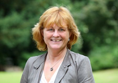 Portraitaufnahme der Gästeführerin Heidi Neumann in einem Park.