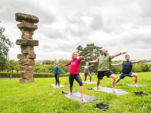 Gruppe beim Yoga auf der Wiese vor dem Kardinal Schulte Haus mit weitem Blick auf Köln