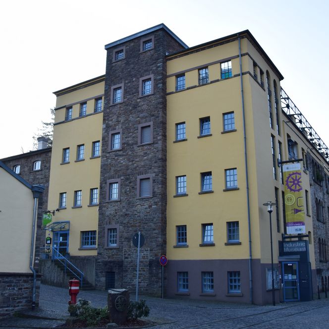 Ehemaliges Industriebauwerk in Engelskirchen, gelber Anstrich und Ziegel, heute ein Industriemuseum.