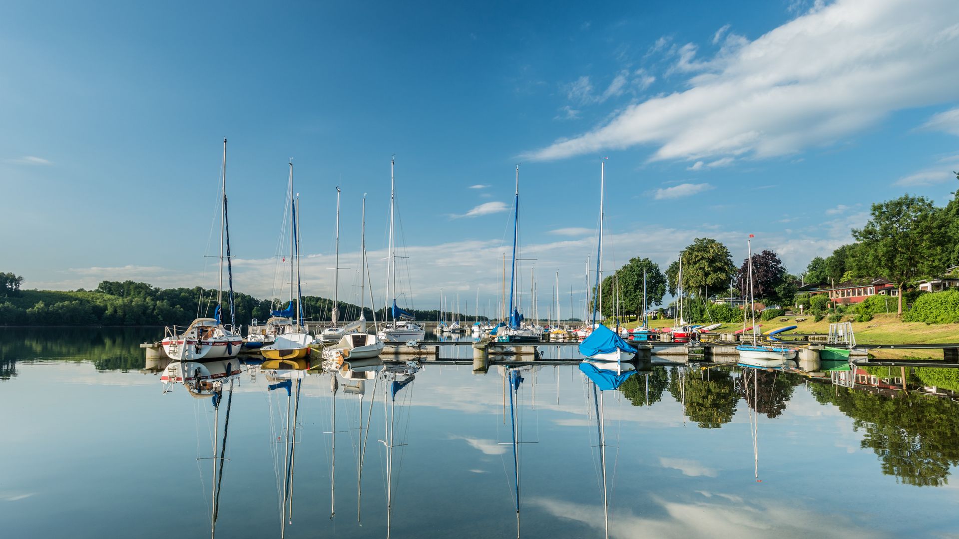 Segelboote am Steg in der Bevertalsperre, Sommer, die Botte spiegeln sich im glatten Wasser
