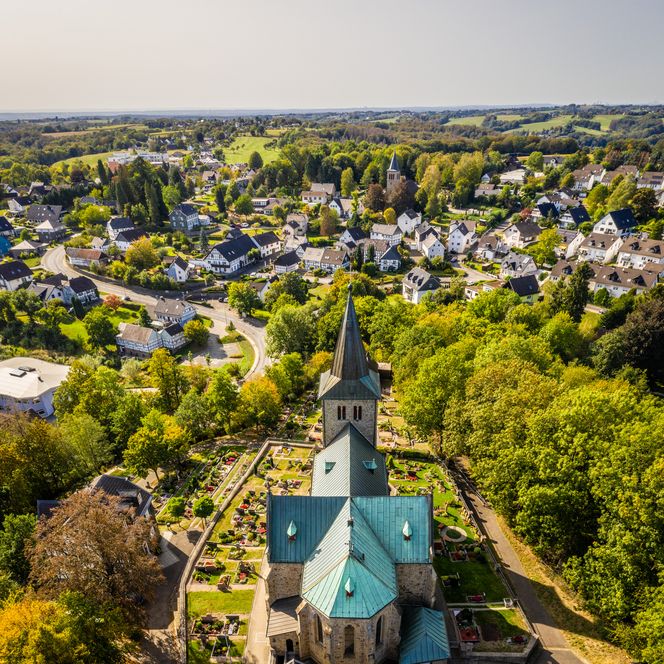 <p>Luftaufnahme von Neunkirchen-Seelscheid mit einer zentral gelegenen Kirche und grüner Umgebung.</p>